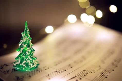 Premium Photo | Old sheet with Christmas music notes as background against blurred lights ...