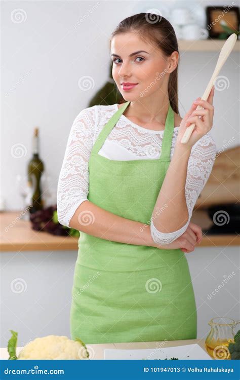 Young Woman In The Green Apron Is Cooking In The Kitchen Housewife Thinking About The Menu