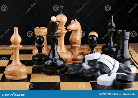 The Chess Pieces And Pile Of Checkers Placed On The Chessboard Stock