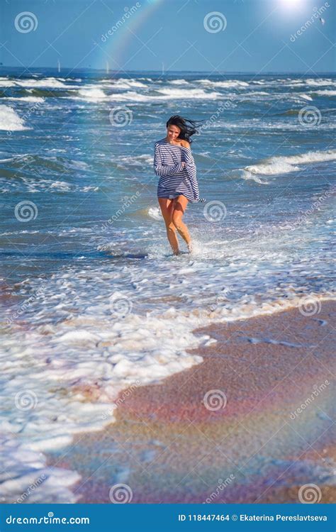 Girl Runs Along The Beach In The Waves Happy State Of Mind Stock Photo