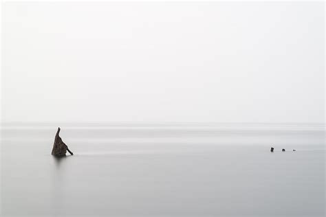 Minimal Landscape Image Of Shipwreck Poking Through Top Of Ocean