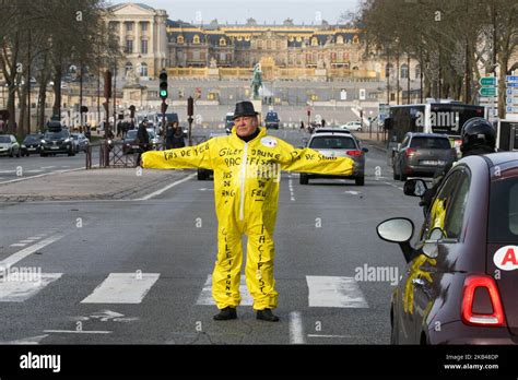 A Protestor Dressed In A Yellow Overall Stands Near The Chateau De