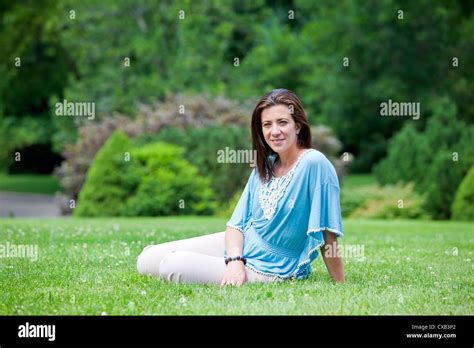 Pretty Brunette Woman Sitting On Grass In Summer Portrait Stock Photo Alamy