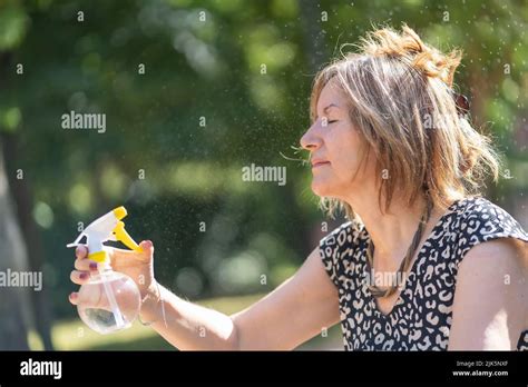 Mature Woman Curving Herself In A Public Park With A Water Vaporizer In The Middle Of Summer
