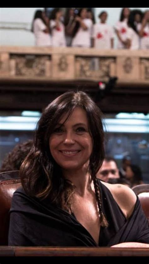 A Woman Sitting In A Chair Smiling At The Camera