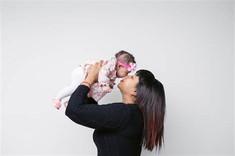 M E E Beb De Etnia Latina Em Bra Os Tocando Rosto Momento Emocional Fundo Branco Foto Premium