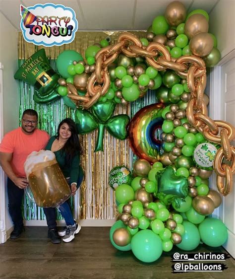 A Man And Woman Standing Next To Each Other In Front Of A Giant Balloon