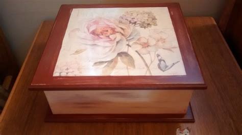 A Wooden Box Sitting On Top Of A Table With Flowers Painted On The Lid