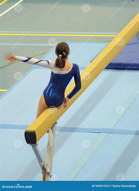 Young Gymnast Girl Performing Routine On Balance Beam Stock Photo