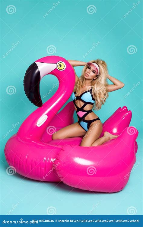 Stunning Blonde Model In A Colorful Bikini Lies On A Pink Flamingo Stock Photo Image Of Legs
