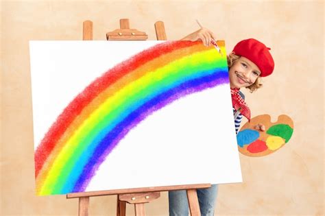 Premium Photo | Happy child painting rainbow at home.