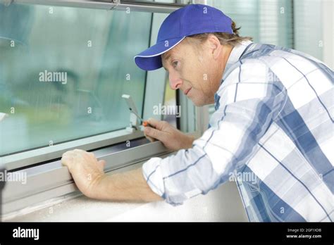 Mature Service Man Installing Window With Screwdriver Stock Photo Alamy