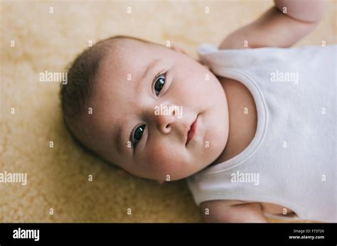 A Baby Girl Lying On Her Back On A Sheepskin Rug Stock Photo Alamy