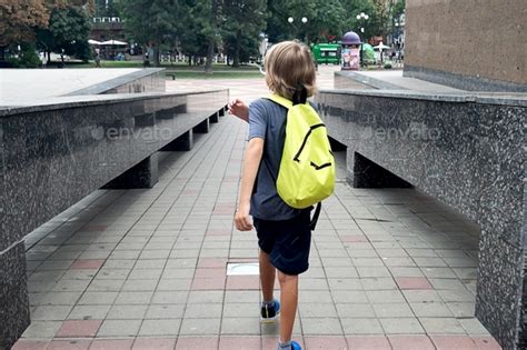 Back To School Happy Blonde Boy Pupil With Green Backpack Goes Home After School Stock Photo By