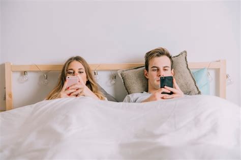 Casal Usando Smartphones Na Cama Foto Gr Tis