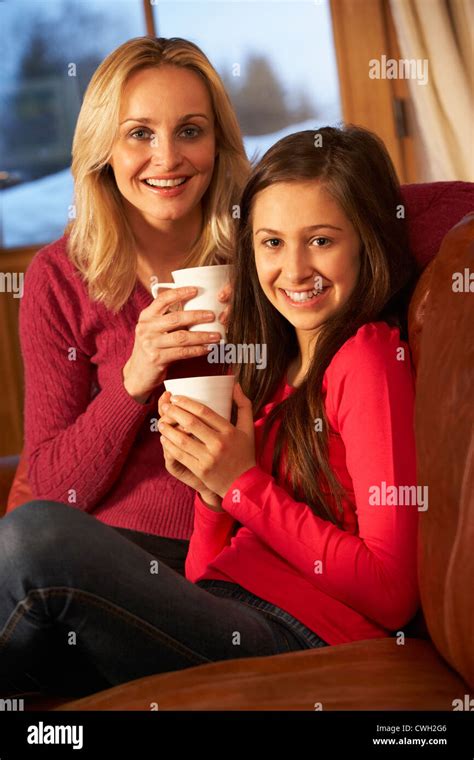 Portrait Of Mother And Daughter Relaxing On Sofa Together With Hot