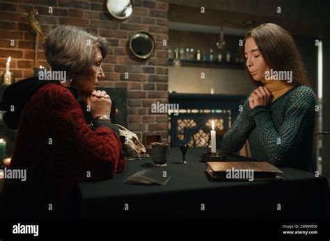 Old Gypsy Fortune Teller And Young Woman Performing Magic Ritual Stock