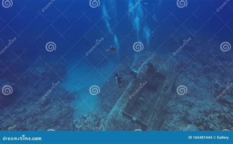 Scuba Divers Scuba Diving Underwater Shipwreck Sunken In Deep Blue Sea