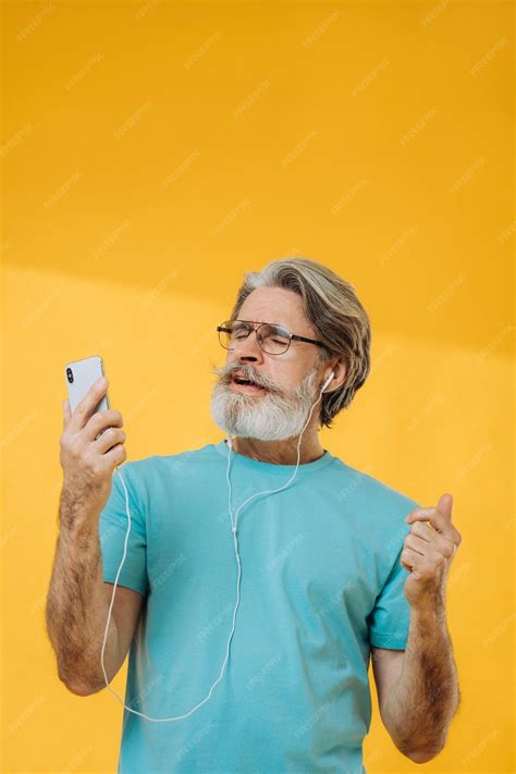 Premium Photo Optimistic Grayhaired Old Man Listens To Music Dances