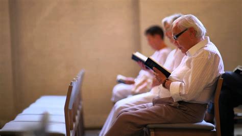 Dolly Shot Of Elderly People Reading The Bible At A Church In