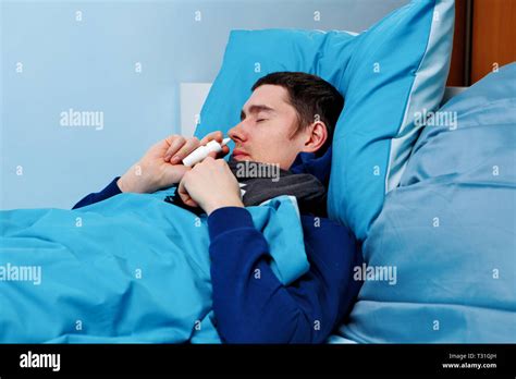 Image Of Sick Man Using Nasal Spray While Lying In Bed Stock Photo Alamy