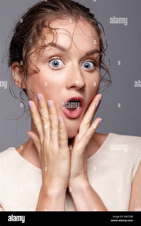 Amazed Young Woman With Hands Near Face And Mouth Open Shocked Girl