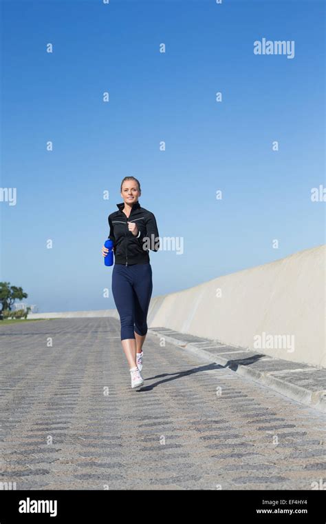 Fit Blonde Jogging On The Pier Stock Photo Alamy