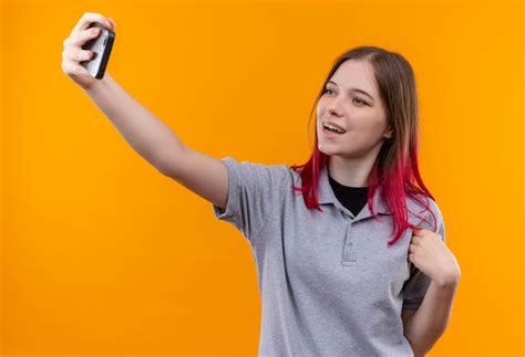 Free Photo Smiling Young Beautiful Girl Wearing Gray T Shirt Taking Selfie On Isolated Yellow