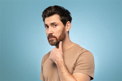 Handsome Caucasian Man Touching His Ideal Beard And Looking At Camera