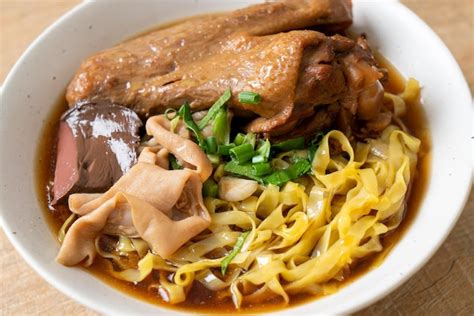 Premium Photo Egg Noodles With Stewed And Braised Duck In Brown Soup