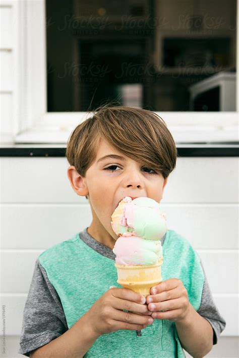 Treat Boy Takes Big Bite Of Ice Cream Cone Del Colaborador De