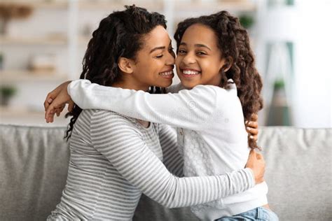 Closeup African Daughter Embracing Mother Sitting Couch Home Stock