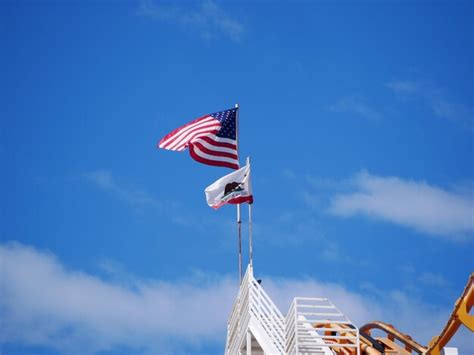 Premium Photo Low Angle View Of Flags Waving Against Blue Sky