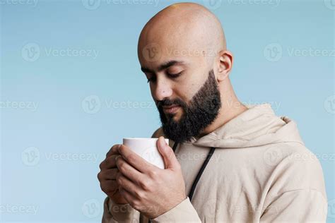 pensativo árabe hombre participación taza y mirando a café con