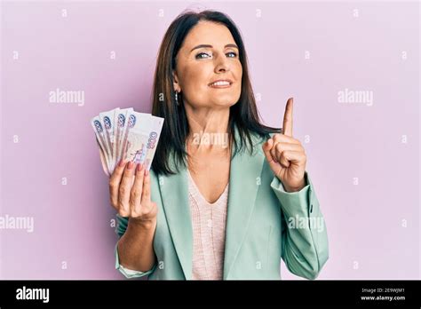 Middle Age Brunette Woman Holding Russian Ruble Banknotes Smiling