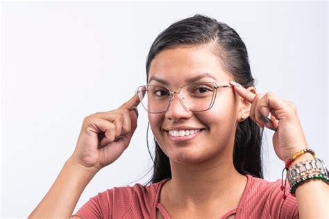 Jovem mulher latina óculos sorridentes apontando no fundo branco Foto Premium