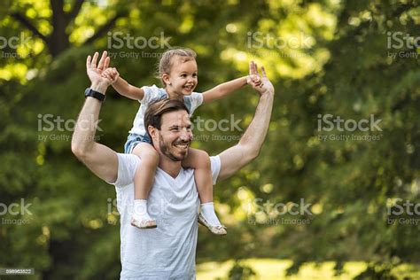 Happy Father Carrying His Small Daughter On Shoulders In Nature Stock