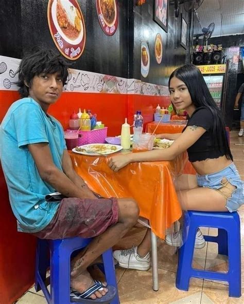 Two People Sitting At A Table Eating Food