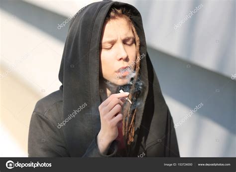 Young boy smoking weed on light background Stock Photo by ©belchonock ...