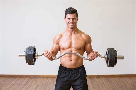 Premium Photo Shirtless Muscular Man Lifting Barbell In Gym