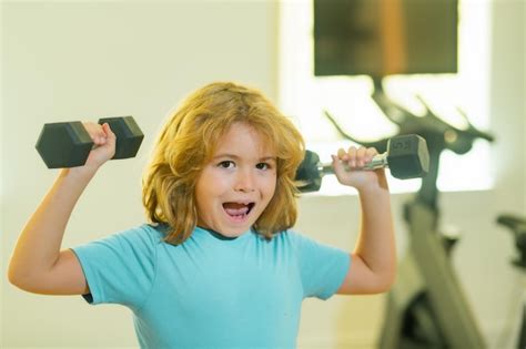 Premium Photo Child Workout Kid In Gym Cute Child Boy Pumping Up Arm