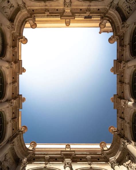 Looking Up At The Sky Through An Arch In A Building With Arches And