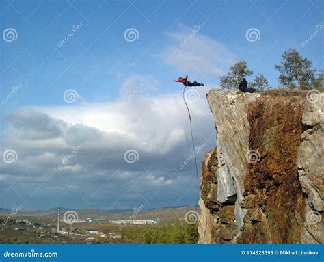 A Man Jumps From The Edge Of The Cliff Into The Abyss Stock Image