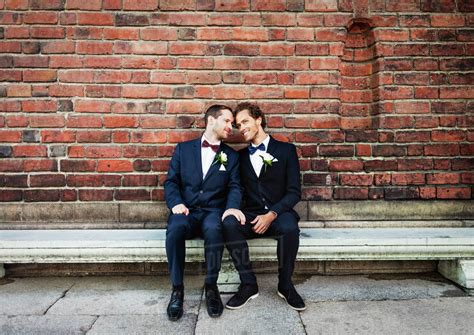 Newlywed Gay Couple Sitting On Bench Against Brick Wall Royalty Free Stock Photo Dissolve