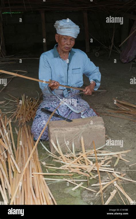 Woman Splitting Bamboo For Weaving Into Traditional Panels For Lining