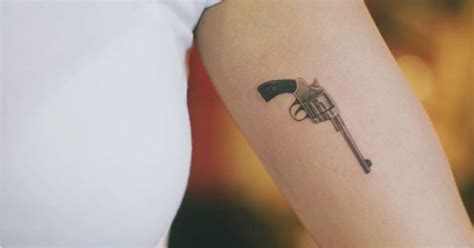 Small Fine Line Style Revolver Tattoo On The Left Inner