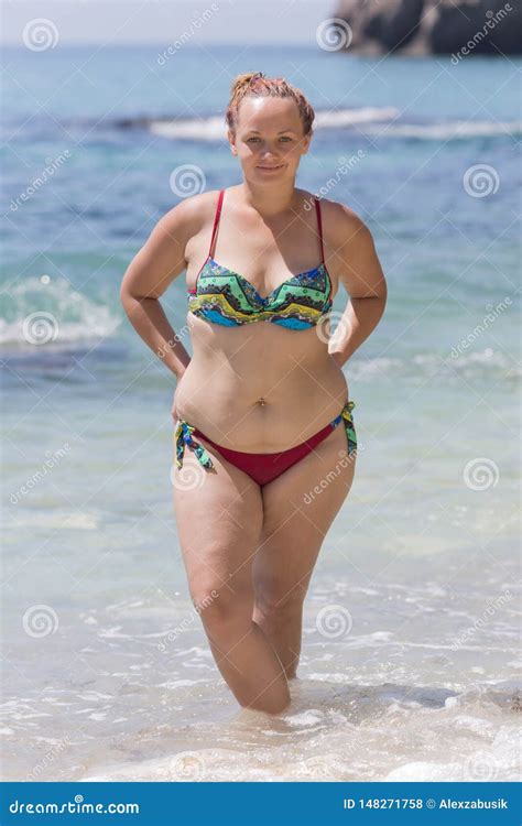 Overweight Female Person In Bikini Posing With Arms Akimbo Stock Photo