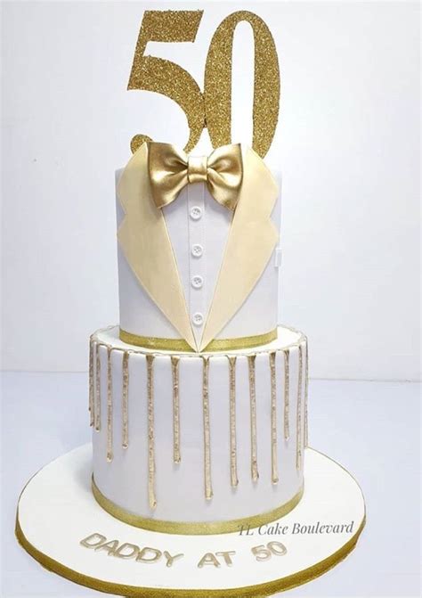 A White And Gold 50th Birthday Cake With A Bow Tie