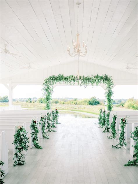 White Open Air Wedding Chapel With Greenery On Aisle And Archway