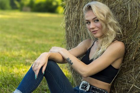 A Lovely Blonde Model Poses Outdoors In A Farm Environment Stock Photo